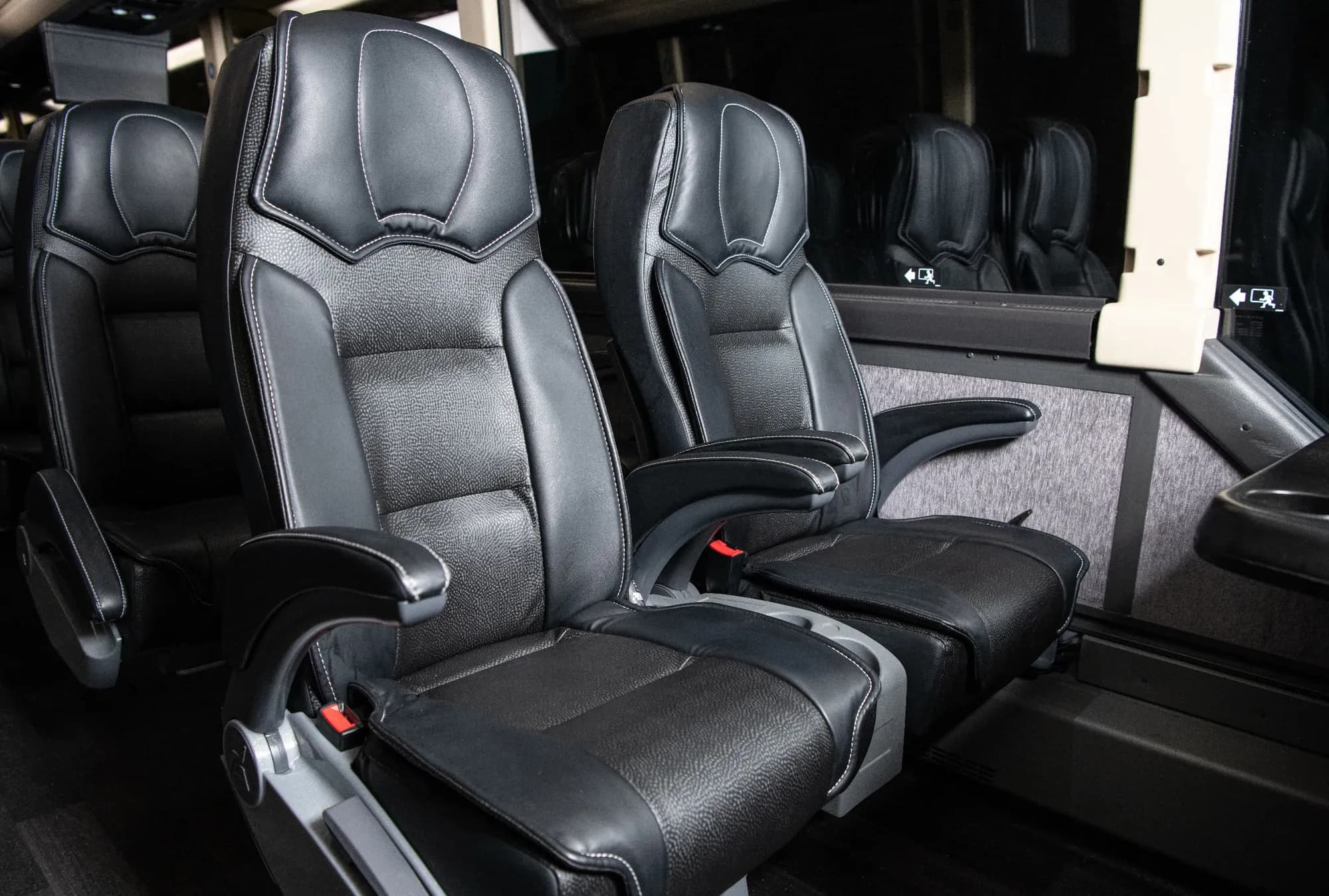 Reclining leather seats with fold-down armrests inside a Landline coach.