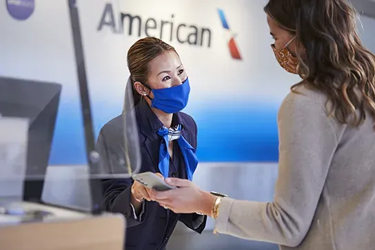 An American Airlines agent helping a traveller at the ticket counter